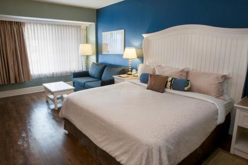 a bedroom with a large bed and a blue wall at Watkins Glen Harbor Hotel in Watkins Glen
