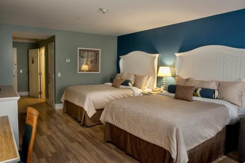 a bedroom with two beds and a blue wall at Watkins Glen Harbor Hotel in Watkins Glen