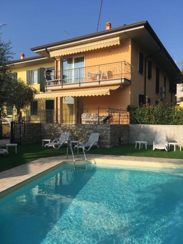 a house with a swimming pool in front of a house at Mary Apartments in Brenzone sul Garda