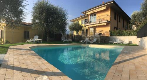 a swimming pool in front of a house at Mary Apartments in Brenzone sul Garda