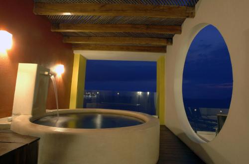 a bathroom with a large tub with a window at Condominio Marlica in Manzanillo