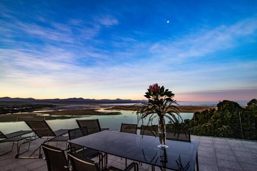 a dining table with chairs and a view of a river at No1 Sangaree in Plettenberg Bay