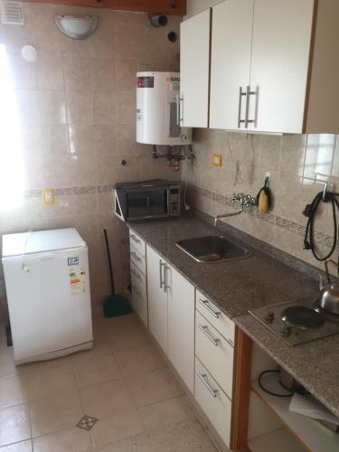 a kitchen with white cabinets and a white refrigerator at Gutyne56 in Puerto Madryn