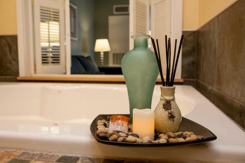 a tray with a green vase and candles on a table at Watkins Glen Harbor Hotel in Watkins Glen