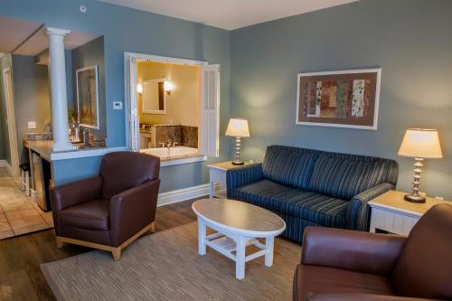 a living room with a couch and a chair and a table at Watkins Glen Harbor Hotel in Watkins Glen