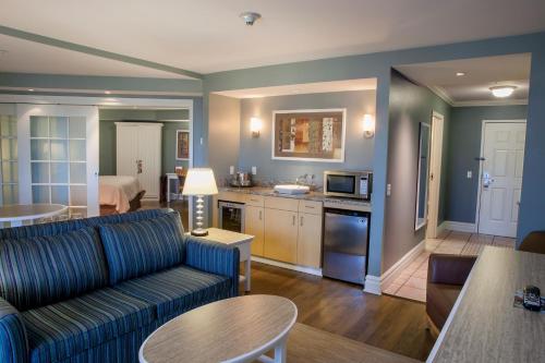 a living room with a couch and a kitchen at Watkins Glen Harbor Hotel in Watkins Glen