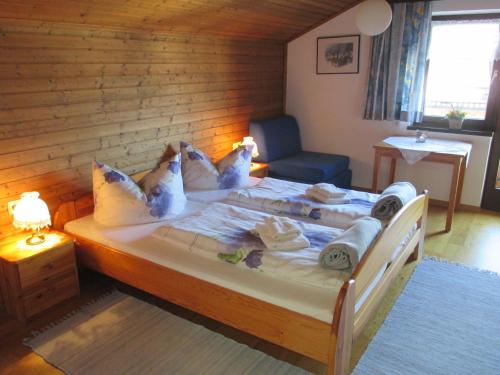 Schlafzimmer mit einem Bett mit weißer Bettwäsche und Kissen in der Unterkunft Haus Schneider in Andelsbuch