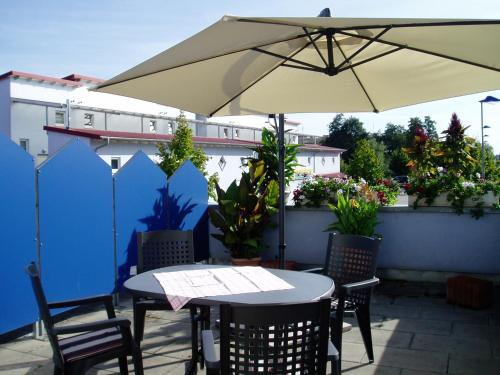 a table and chairs with an umbrella on a patio at Apartment Carmen in Rust
