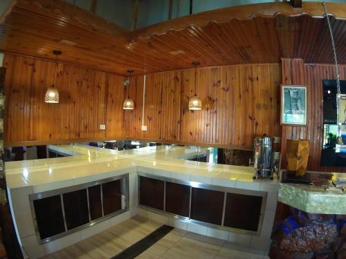 una cucina con pareti rivestite in legno e bancone di Hotel Talu ad Angatuba