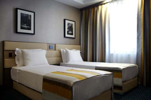 a hotel room with two beds and a window at Tophane Suites in Istanbul