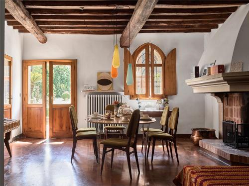 a dining room with a table and chairs and a fireplace at Le dimore de Il borgo del balsamico in Albinea