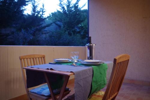 ローマにあるMaMaViHouseのテーブル(緑のテーブルクロス付)とワイン1本