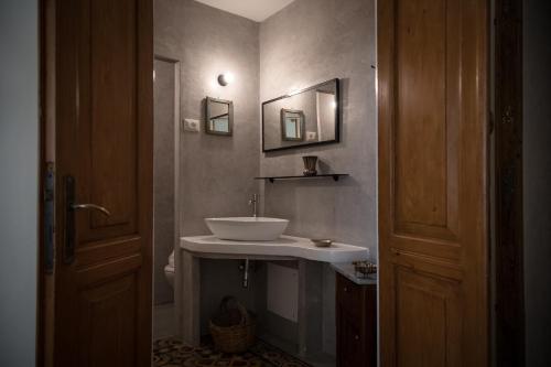 a bathroom with a white sink and a mirror at Piazza San Pantaleo in Sorso