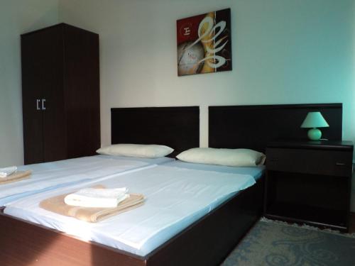 1 dormitorio con 1 cama con 2 toallas en Motel Le Village en Skopie