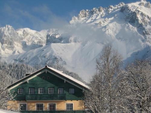 a house in front of a snow covered mountain at Appartement "Haus Lisa" in Ramsau am Dachstein in Ramsau am Dachstein
