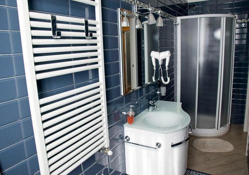 La salle de bains est pourvue de carrelage bleu, de toilettes et d'une douche. dans l'établissement B&B Borfuro, à Bergame