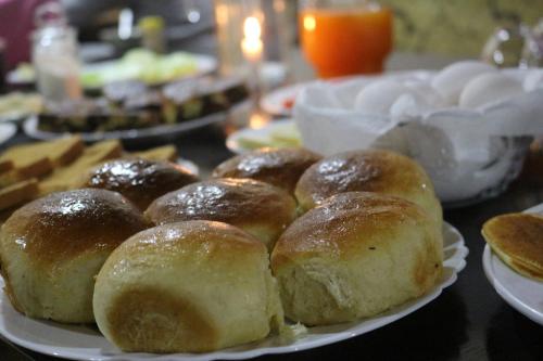 a table with plates of buns and other food at Guest House Keti Margiani Mestia in Mestia