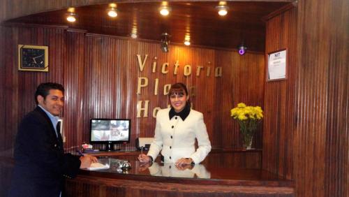 a man is standing at a bar in a restaurant at Hotel Victoria Plaza in Tarija