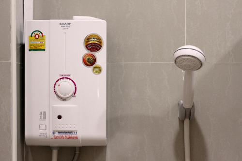 un dispenser di sapone sul muro di un bagno di Khaohom Resort a Nakhon Nayok