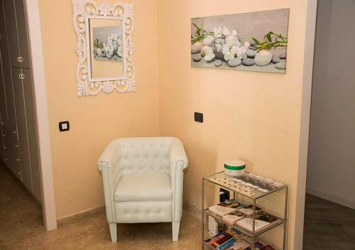 a room with a white chair and a glass table at B&B Borfuro in Bergamo