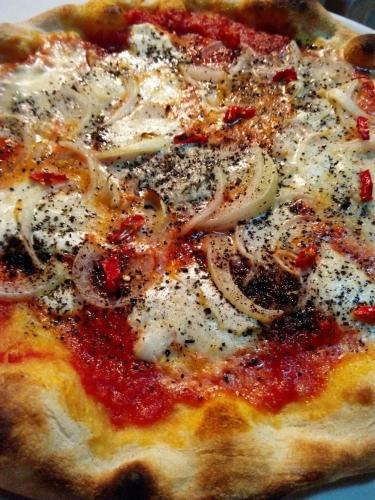 a pizza with cheese and onions on a table at Nido delle Rondini hotel Ristorante Pizzeria in Fallo