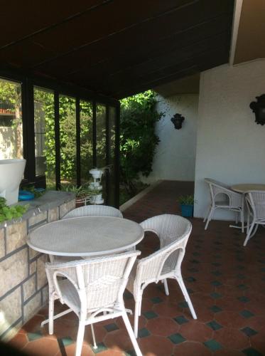 a patio with a table and chairs and windows at Casa Dos Oliva in Alcobaça