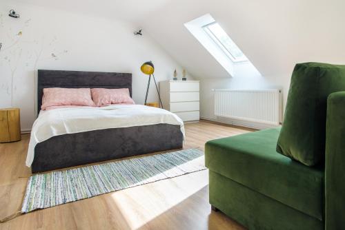 a bedroom with a bed and a green couch at Zöldbarát Vendégház in Nyíregyháza