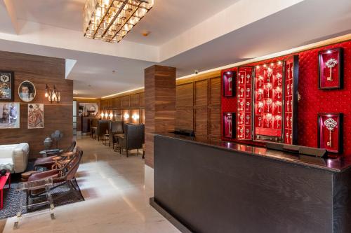 a bar in a hotel with a red wall at The Wild Oscar in Mexico City