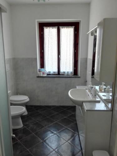 a bathroom with two toilets and a sink and a window at Appartamento Ormeni in Cardano al Campo