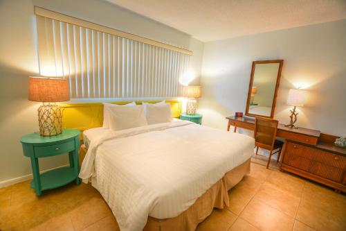 a bedroom with a bed and a desk and a mirror at Sea Cliff Hotel in Fort Lauderdale