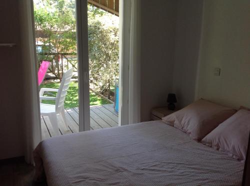 - une chambre avec un lit et une porte coulissante en verre dans l'établissement Appart & p'tit Jardin, à Arès