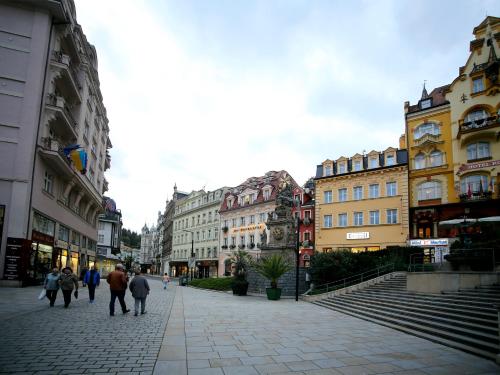 a group of people walking down a street with buildings at Apartmán u Vřídla, ul. Tržiště. in Karlovy Vary