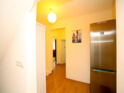 a kitchen with a stainless steel refrigerator and a hallway at Apartmán u Vřídla, ul. Tržiště. in Karlovy Vary