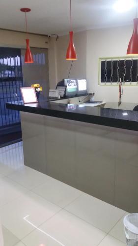 a counter in a restaurant with red lights at Hotel Hawai in Ceilândia