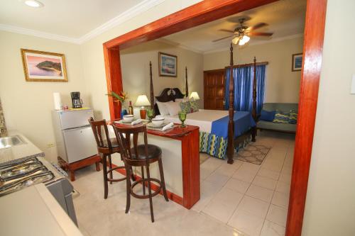 a room with a kitchen and a bedroom with a bed at Rayon Hotel in Negril