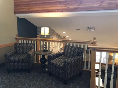 a living room with two chairs and a table at AmericInn by Wyndham Hotel and Suites Long Lake in Long Lake