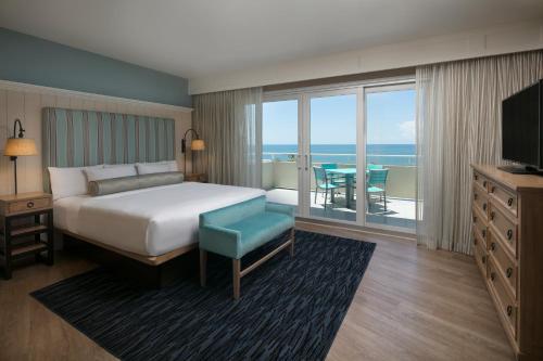 فندق إدجواتر بيتش في نيبلس: غرفة نوم مع سرير وإطلالة على المحيط