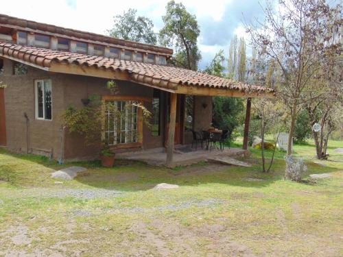 a small house with a patio and a table at Cabañas Puente Negro in Puente Negro