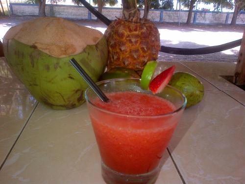 una bebida sentada en una mesa con un montón de fruta en Hostal Camping Beach, en Salinas