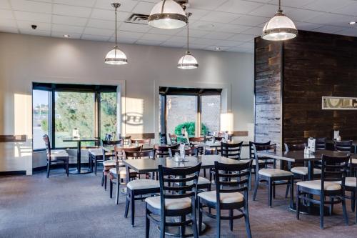 a dining room with tables and chairs and windows at Heritage Inn Hotel & Convention Centre - Taber in Taber