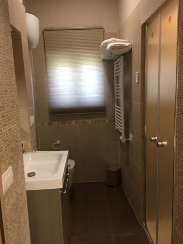 ein Bad mit einem Waschbecken, einem WC und einem Fenster in der Unterkunft Villa Augustea in Somma Vesuviana