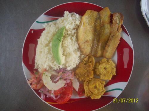 a red and white plate of food with rice and bread at Hostal Camping Beach in Salinas