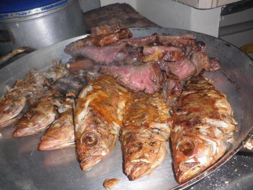 a bunch of fish and meat on a pan at Hostal Camping Beach in Salinas