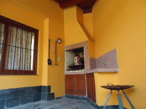 a room with a yellow wall with a counter and a stool at Casa en B° Tres Cerritos, Salta Capital. Alquiler Temporal in Salta