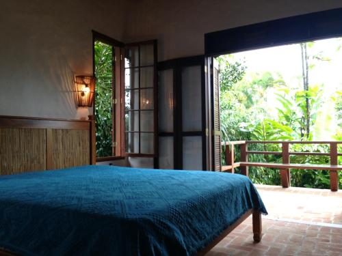 a bedroom with a bed and a large window at The Rainforest Beach House - 200m from beach in Barra do Una