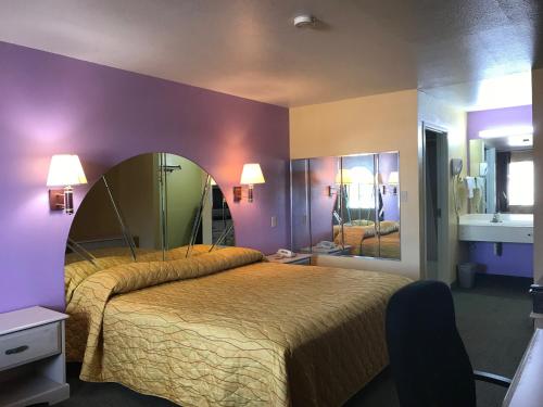 a bedroom with a large bed with a large mirror at Heights Inn in Harker Heights