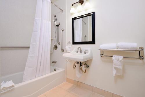 a white bathroom with a sink and a bath tub at Best Western Plus LA Mid-Town Hotel in Los Angeles