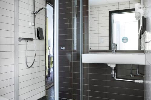 a bathroom with a sink and a shower at Comfort Hotel Kristiansand in Kristiansand
