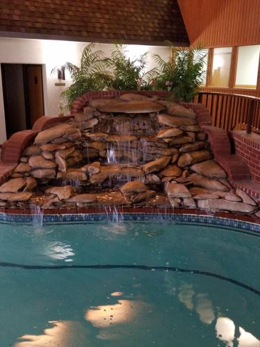 a swimming pool with a waterfall in a house at Apple Tree Inn in Independence