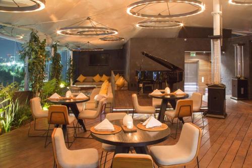 um restaurante com mesas e cadeiras e um piano em Suites Contempo em Cidade do México